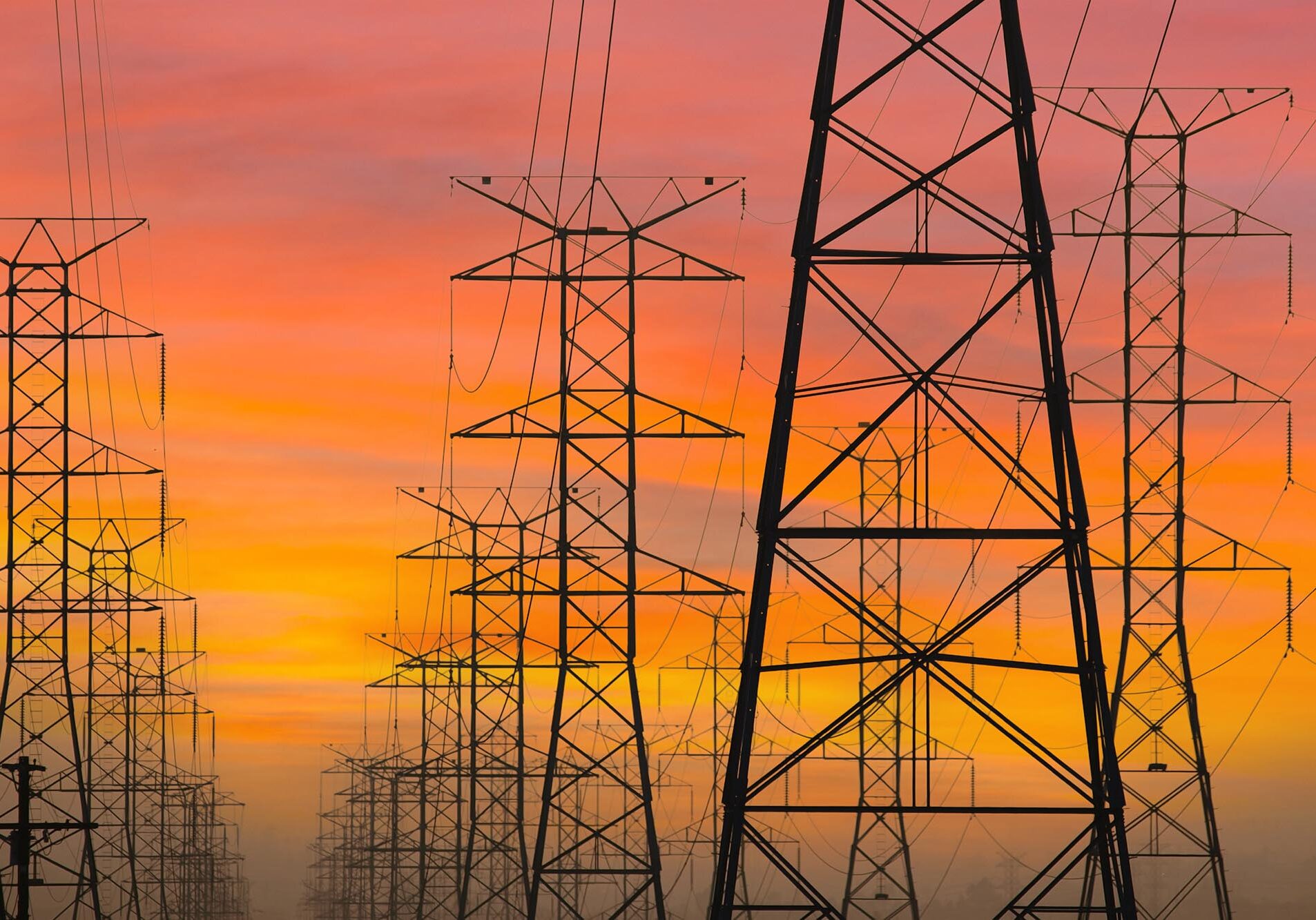 Three rows of power towers with sunrise sky in Los Angeles, California.